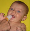 Checking baby's gums and teeth with a damp cloth.